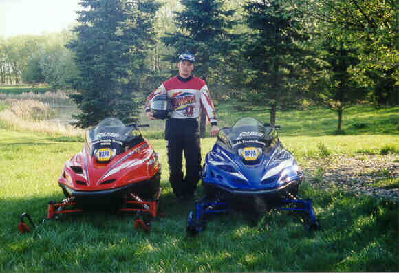 Here is Jamie with his two race sleds.  The red one (a 1997 Yamaha 700 SX) is non-traction, while the blue one (a 1998 Yamaha 700 SX) has 240 studs.